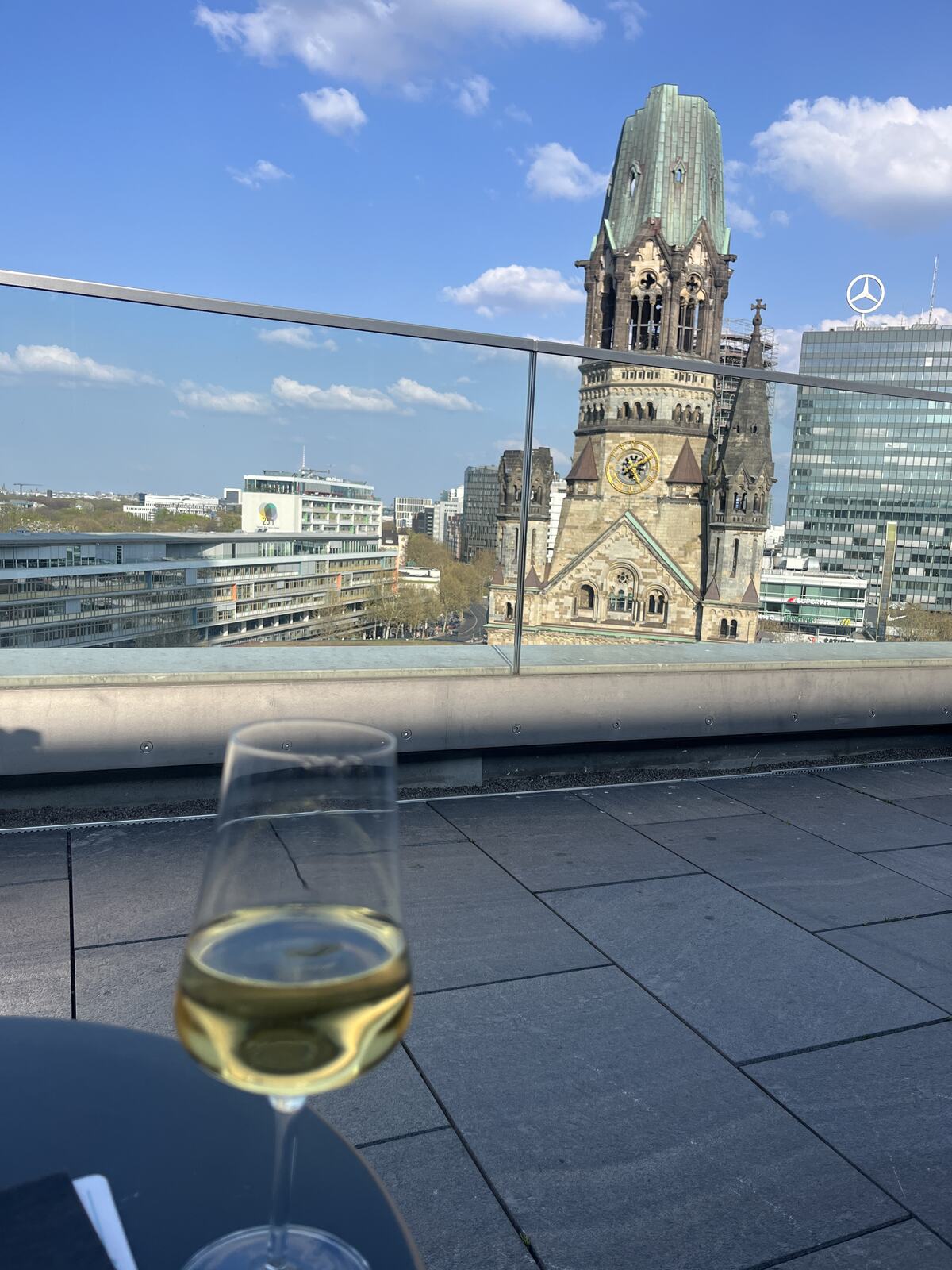 A glass of wine with a view of the Kaiser Wilhelm Memorial Church in Berlin