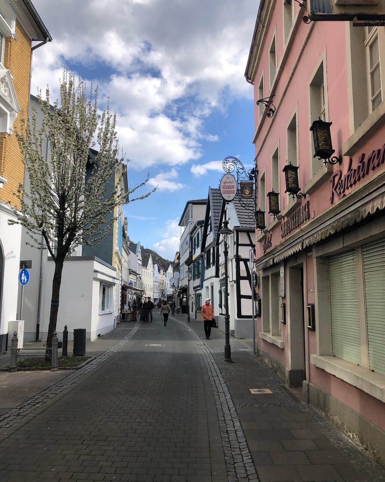 A cobblestone street in the Siebengebirge area near Bonn, with the pink Hotel Siebengebirge