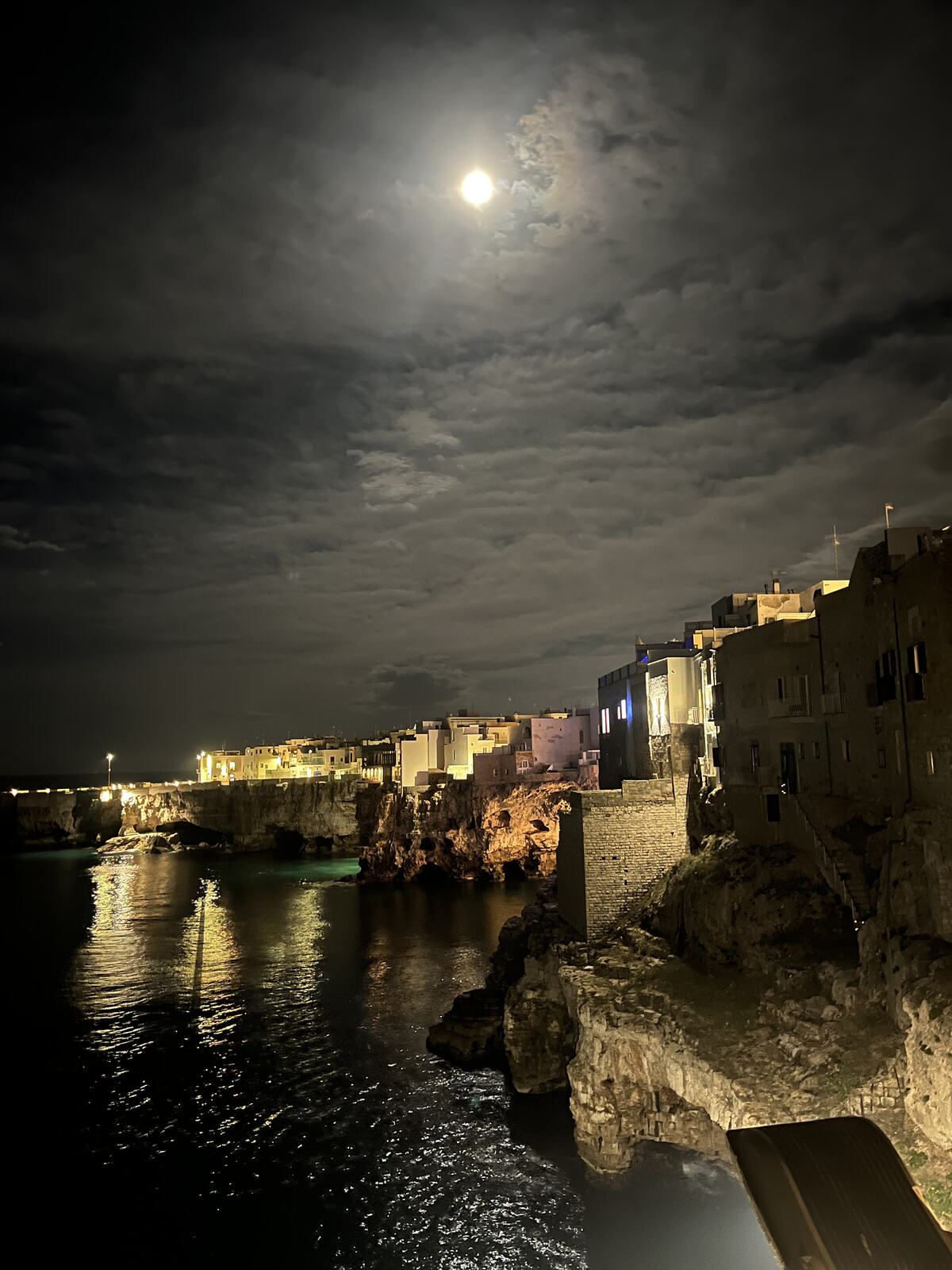 Full moon over the cliffs of Polignano a Mare at night