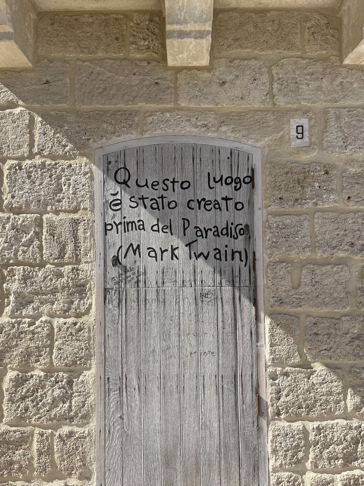 A wooden door with a Mark Twain quote in Italy